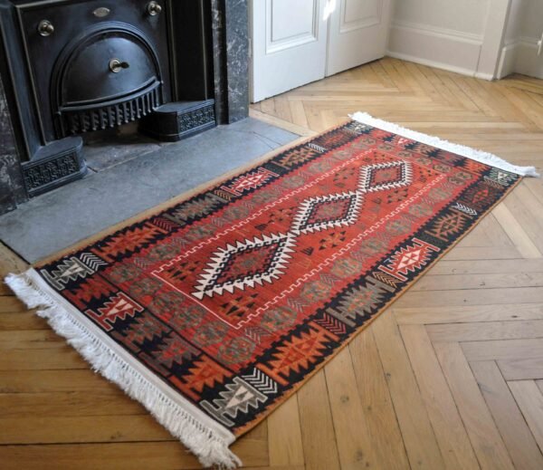 Petit tapis rouge et noir pour chambre avec motifs tribaux